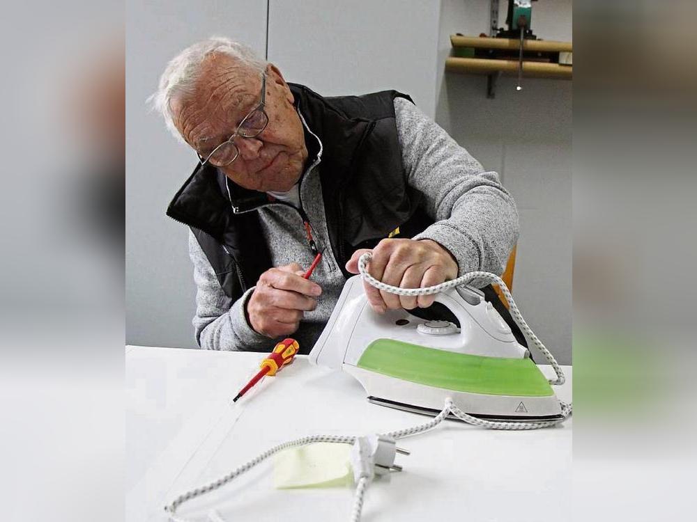 Gar nicht so einfach: Manfred Nölle tauscht das Kabel eines Bügeleisens. Foto: Löseke