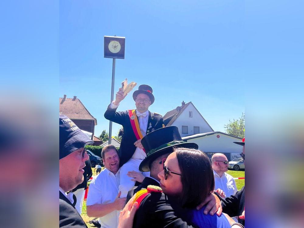 Vom Hauptmann zum König! Die letzten Holzfetzen formt Dominik Friedrich vor dem leeren Kugelfang zu einem Victory-Zeichen, seine Frau Katharina lässt sich derweil beglückwünschen. Foto: Vielberg 