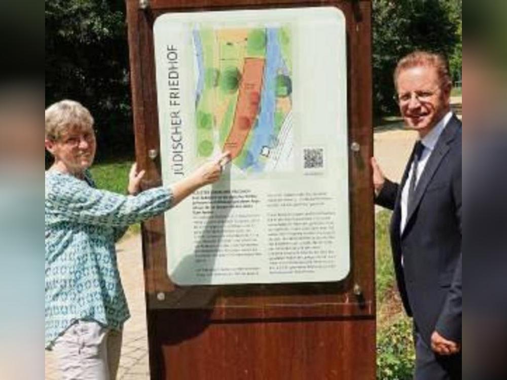 Elisabeth Kloke-Kemper (Verein Judentum in Salzkotten) und Bürgermeister Ulrich Berger neben der Stele, die Infos zum Friedhof gibt.