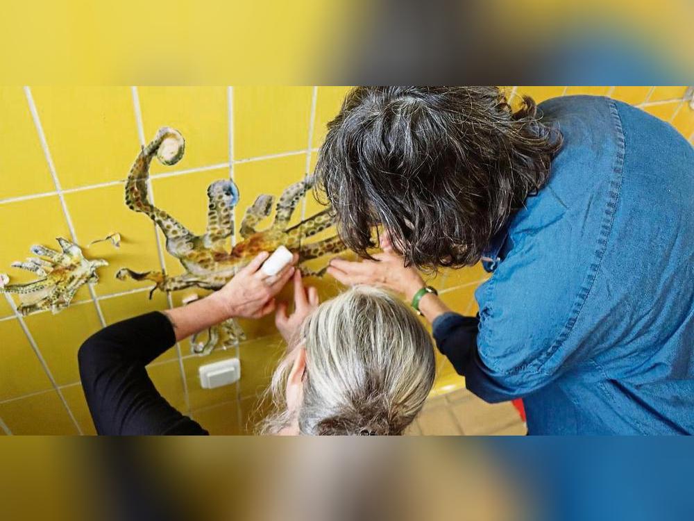 Brigitte und Marianne vom Künstler-Kollektiv Protoplast kleben die Oktopusse im „gelben Salon“ auf. Foto: Dietz