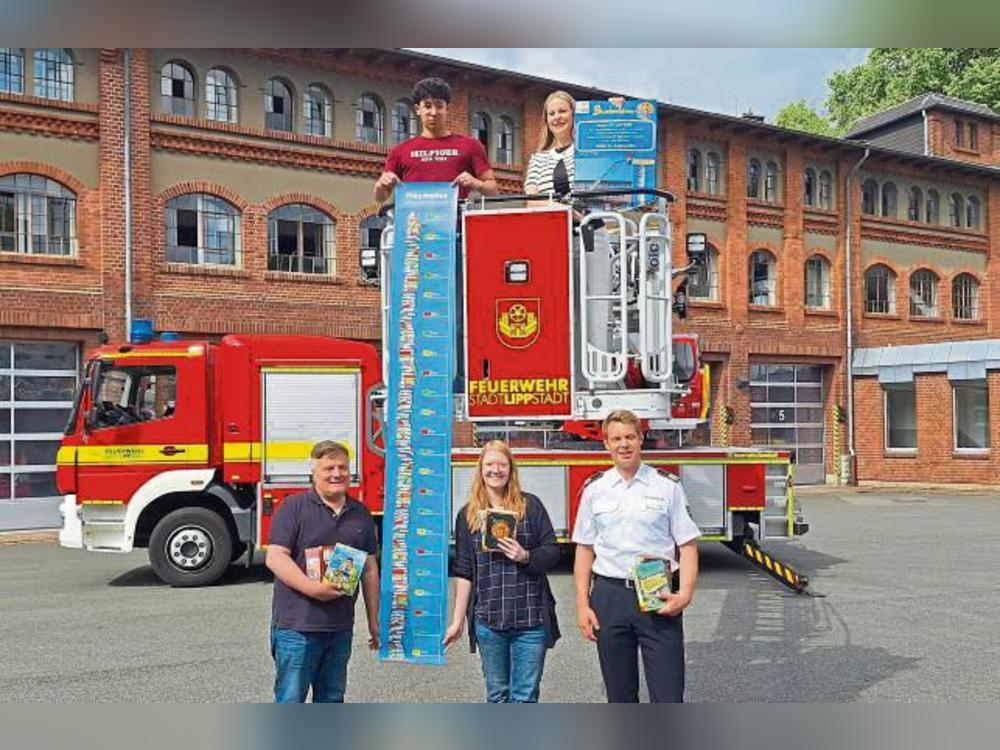 Stadtbücherei-Leiterin Tahnee Exner mit Praktikant Anwar Oun (oben), Bürgermeister Arne Moritz, Kathrin Heberle (Stadtbücherei) und Boris Surendorf (Feuerwehr Lippstadt).