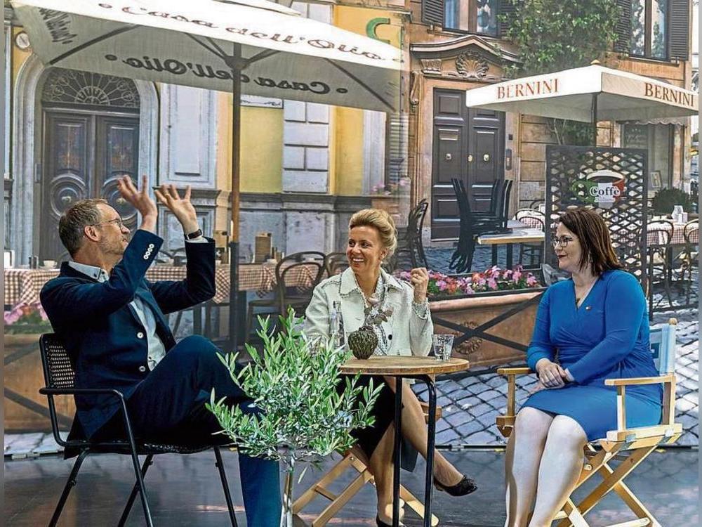 Modernste Medientechnologie macht es möglich: Bei der Eröffnung des Visual Effects Labores trafen sich NRW-Wissenschaftsministerin Ina Brandes (M.), HSHL-Präsidentin Kira Kastell und Projektleiter Stefan Albertz mal schnell zum Plausch in einem italienischen Café.