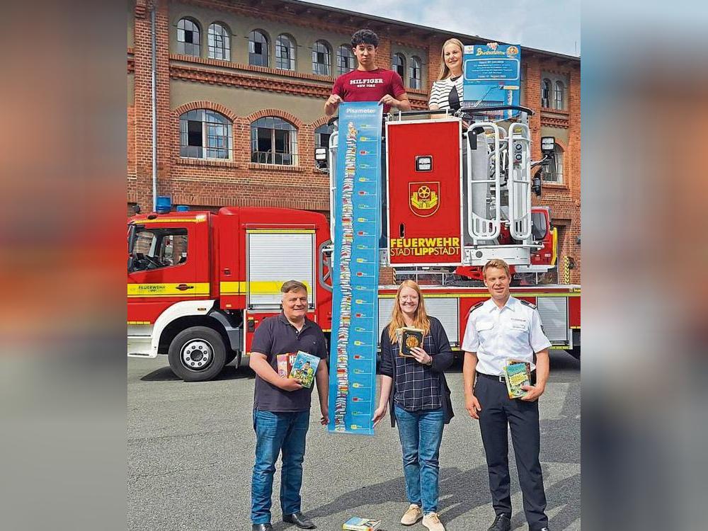 Wer lesen kann, kann Türme bauen: Stadtbücherei-Leiterin Tahnee Exner mit Praktikant Anwar Oun (beide oben), Schirmherr Bürgermeister Arne Moritz, Kathrin Heberle (Stadtbücherei) und Boris Surendorf (Feuerwehr Lippstadt).