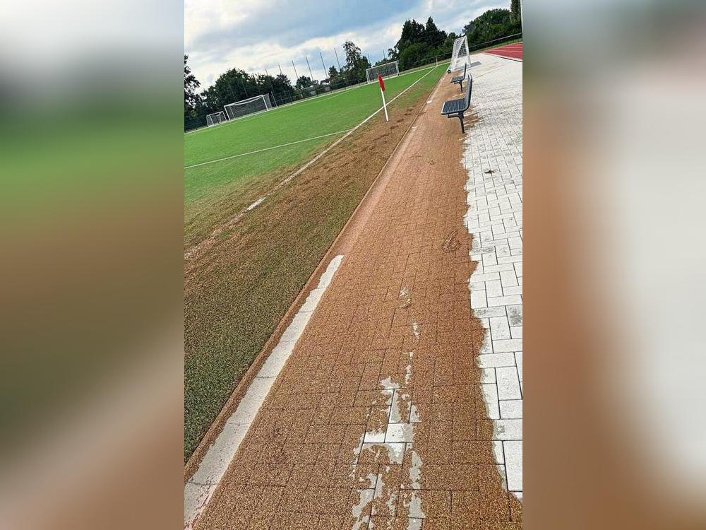 Nach dem Regen ist vor dem Fegen: Viel Kork hatte sich neben dem neuen Erwitter Kunstrasen verteilt.