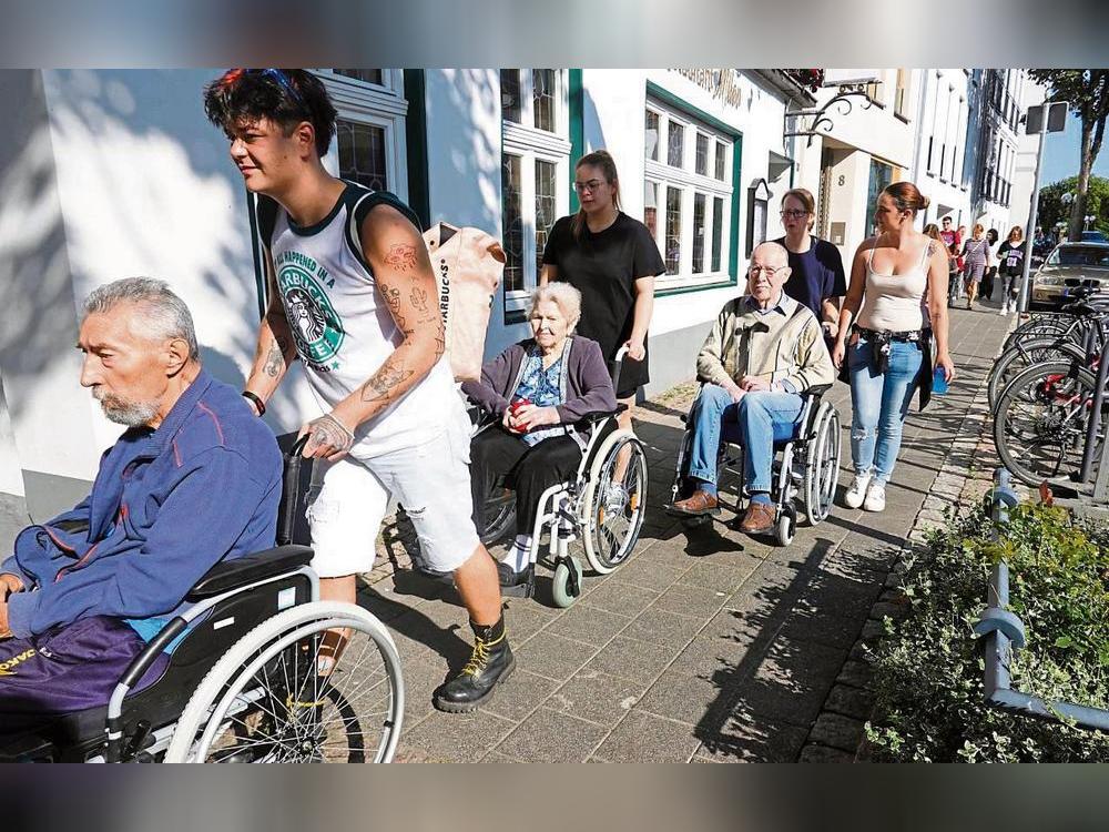 Umzugs-Kolonne: In einem Konvoi aus Rollstühlen und Rollatoren ging es am Dienstagvormittag für 30 Heimbewohner von der Burgstraße in das Quartier Südliche Altstadt, die Senioren wurden von Angehörigen und Pflegeschülern begleitet. Zehn bettlägerige Bewohner sind in Krankenwagen liegend transportiert worden. Fotos: Vielberg