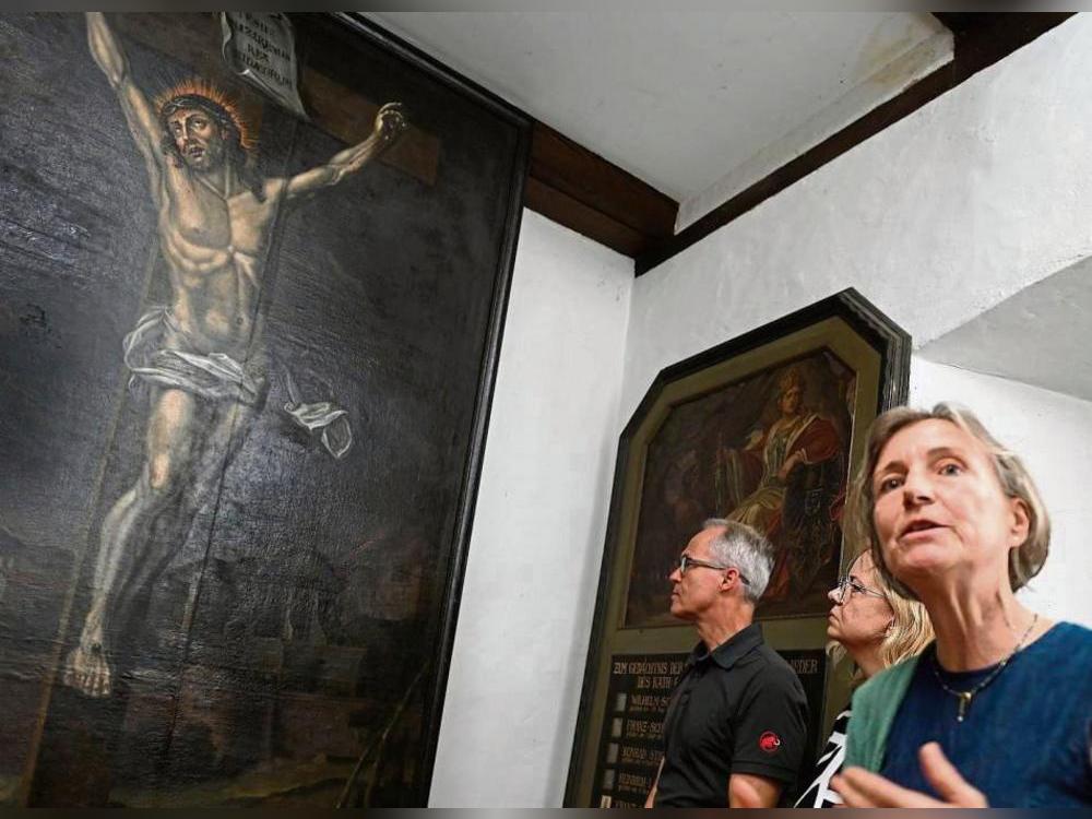 Monika Voss-Raker erläutert den Besuchern die aufwendige Restaurierung des Altarbildes „Christus am Kreuz“. Fotos: Tuschen