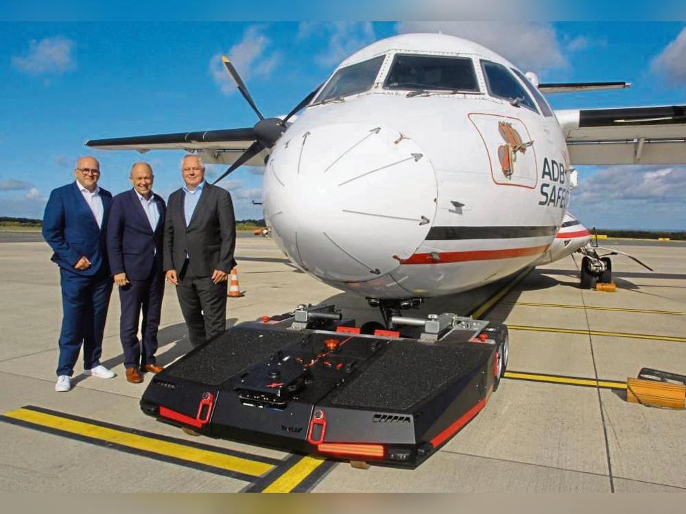Noch hat das Schleppgerät für Flugzeuge nicht mal einen Namen – aber das Startsignal für eine sechsmonatige Testphase gaben (v.l.) Flughafen-Chef Roland Hüser, Landrat und Aufsichtsrat-Vorsitzender Christoph Rüther und Konsortialführer Stefan Schröder. Foto: Schwade