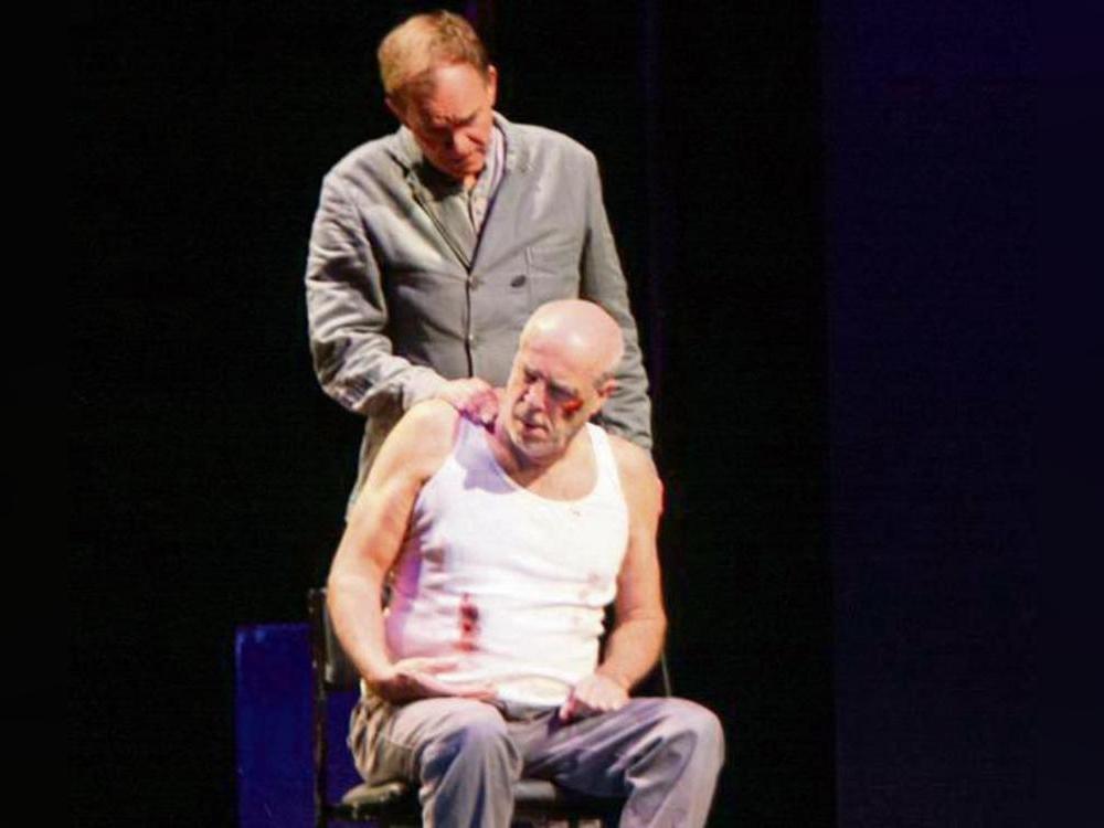 O’Brien (Marcus Widmann stehend) spielt ein perfides Spiel mit Winston Smith (Peter Kremer). Foto: Helga Wissing