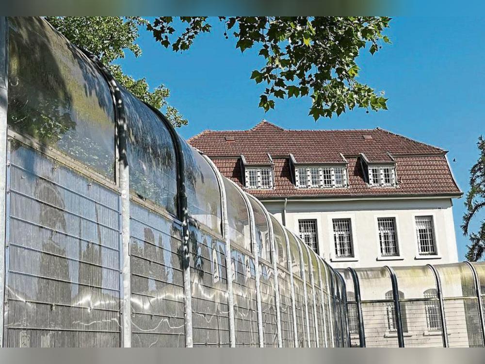 Hinter dem Zaun der Forensik sind die Patientinnen unzufrieden. Foto: Dominik Friedrich