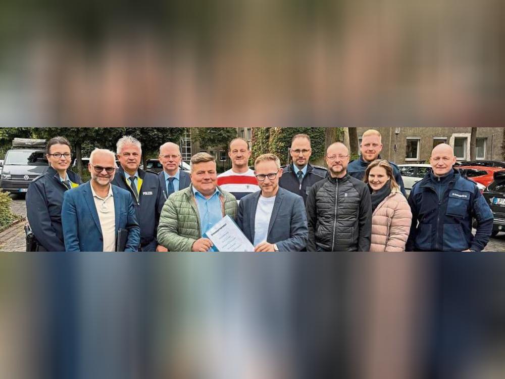 Gemeinsam handeln für Vertrauen und Sicherheit: Bürgermeister Arne Moritz und Ordnungsamtsleiter Thorsten Schmidt (Mitte) präsentieren die Vereinbarung, die vor 20 Jahren die Gründung der Ordnungspartnerschaft besiegelte.