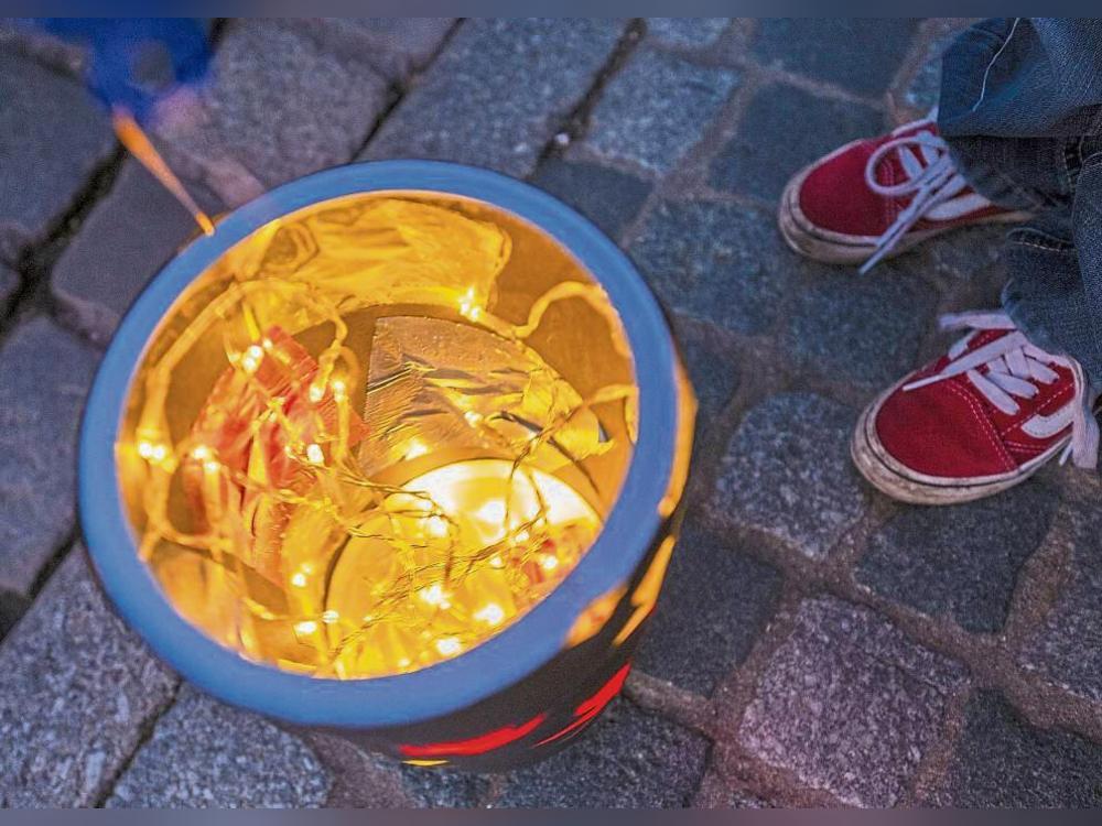 Kinder ziehen mit leuchtenden Laternen durch den Ort: Der Martinsumzug soll auch künftig die Tradition des Teilens lebendig halten. Foto: dpa