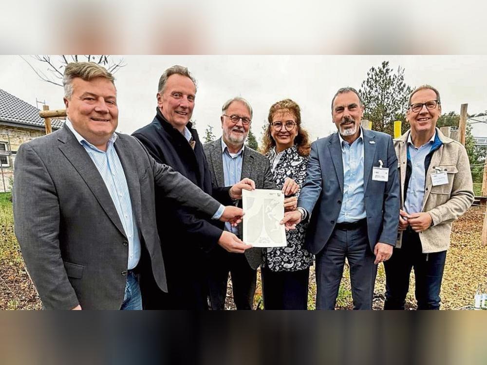 Da ist das Ding! Thomas Sommer (2.v.l) von der Bezirksregierung Arnsberg überreichte den Förderbescheid an (v.l.) Lippstadts Bürgermeister Arne Moritz, Joachim Drüke (Abu), Carmen Harms (KWL) und Matthias Lürbke (Bürgermeister Lippetal). Auch zur Freude von Hubertus Winterberg, Geschäftsführer der Südwestfalen Agentur. Foto: Ursula Vielberg