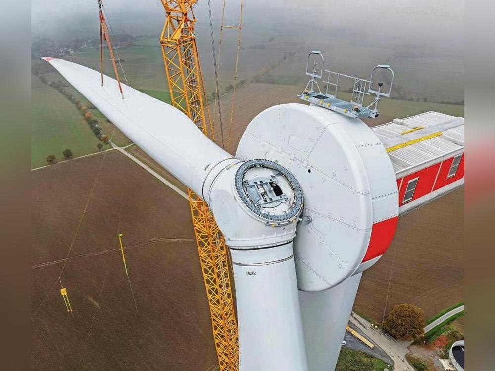 Mit einem Spezialkran wurden die Flügel der Windräder an der Spitzen Warte installiert. Unter den tiefen Wolken schemenhaft erkennbar: Menzel. Foto: Bernd Eickhoff