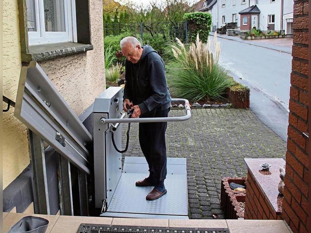 Wienand Fromme zeigt, wie der Treppenlift für Rollstühle an seinem Haus funktioniert. Er würde den Lift gerne an eine Familie mit Bedarf verschenken. Foto: Pia Mintert