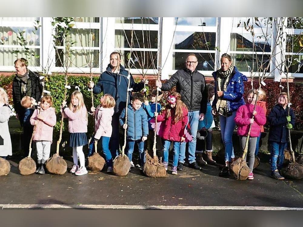 Die Erstklässler der Alexanderschule in Mellrich freuten sich über die Obstbäume, mit ihnen auch (v.l.) Marvin Knaden von Provinzial Anröchte, Bürgermeister Alfred Schmidt und Schulleiterin Sonja Kleine. Foto: Reinhard Priesnitz