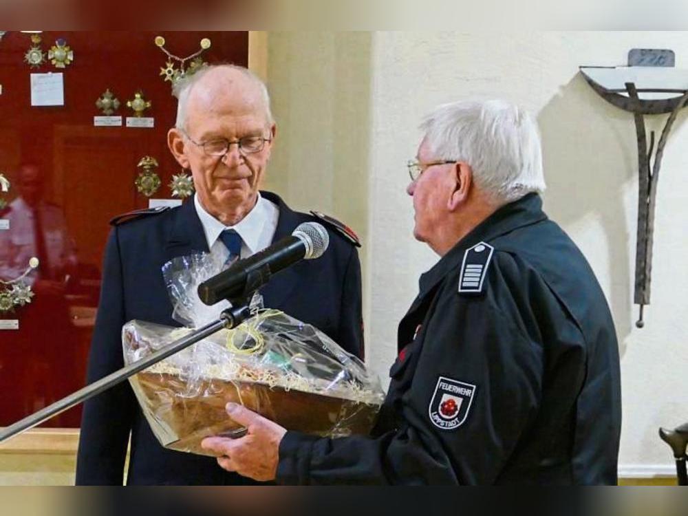 Unter großem Applaus überreichte Stadtbrandmeister i.R. Uli Schiwek (r.) einen liebevoll gestalteten Präsentkorb. Bewegt bedankte sich Norbert Sandmeyer (l.). Foto: Dreier (Feuerwehr)