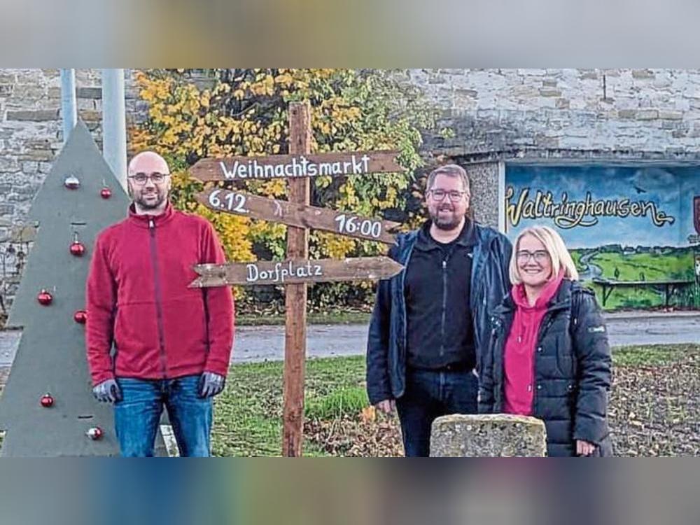 In Waltringhausen sind vom Verein „Waltringhausen Aus Sympathie“ Schilder für den siebten Weihnachtsmarkt 2025 montiert worden, zu sehen sind (v.l.) Emanuel Aßhoff, Alexander Koch und Anja Pöppelbaum. Foto: Reinhard Priesnitz