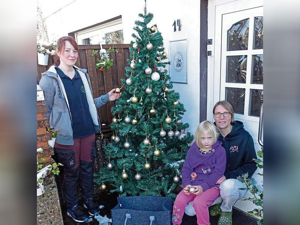 Vom Wunschbaum vor der Praxis von Tierärztin Stefanie Scholz (r.) können jederzeit Kugeln mit Wünschen von Tierheimbewohnern gepflückt werden. Foto: Marcus Kloer