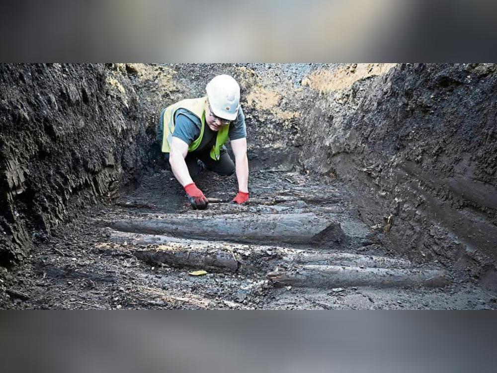 In 1,50 Meter Tiefe legt der Archäologe Philipp Rethwisch den mittelalterlichen Bohlenweg unter der Langen Straße in Rietberg frei. Foto: LWL-AfW/S. Spiong