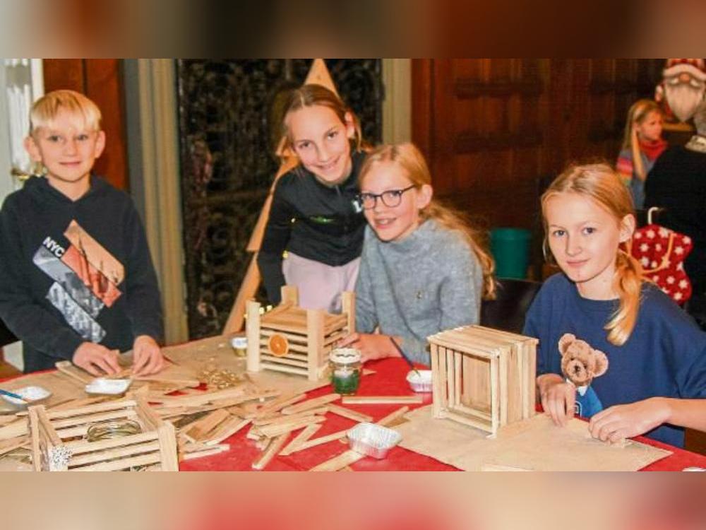 Nathanael (l.) baut an diesem Tisch, gemeinsam mit anderen Kindern, dekorative Windlichter aus Holz.