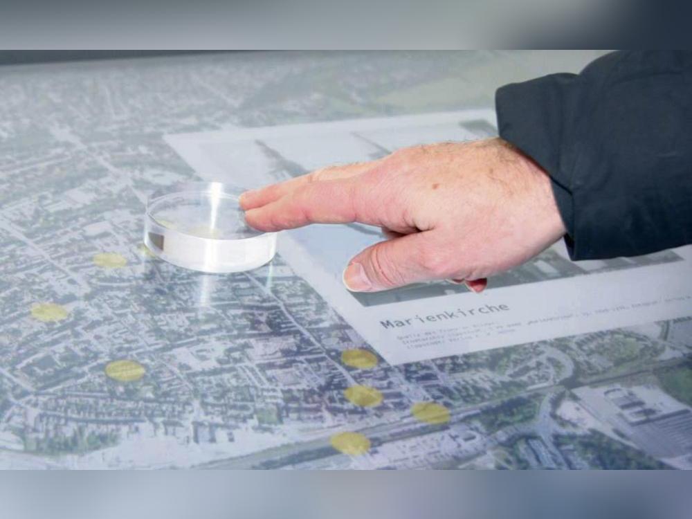 Auf dem Multi-Touch-Tisch kann man eine interaktive digitale Stadtkarte von Lippstadt bedienen. Das System reagiert auch auf physische Objekte, sogenannte Tangibles. Fotos: Helga Wissing