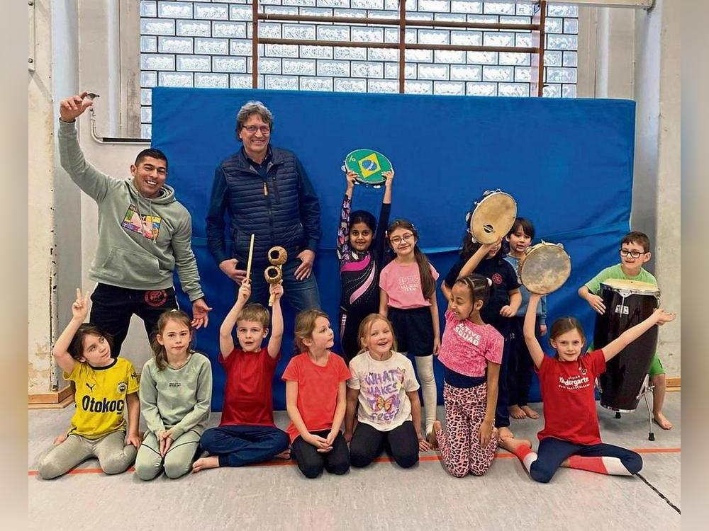 Capoeira-Profi William Gomes Soares von Viva Brasil (hinten, l.) und Schulleiter Andreas Brauckmann (hinten, 2.v.l.) freuen sich mit den Friedrichschülern über das neue Angebot.
