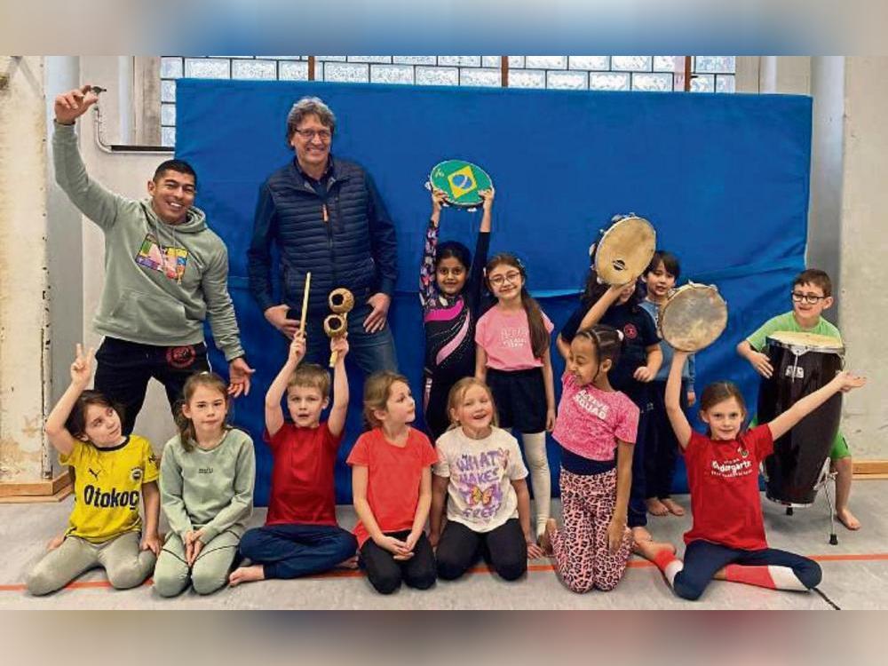 Capoeira-Profi William Gomes Soares (l.) und Schulleiter Andreas Brauckmann (hinten, 2.v.l.) mit den Friedrichschülern.