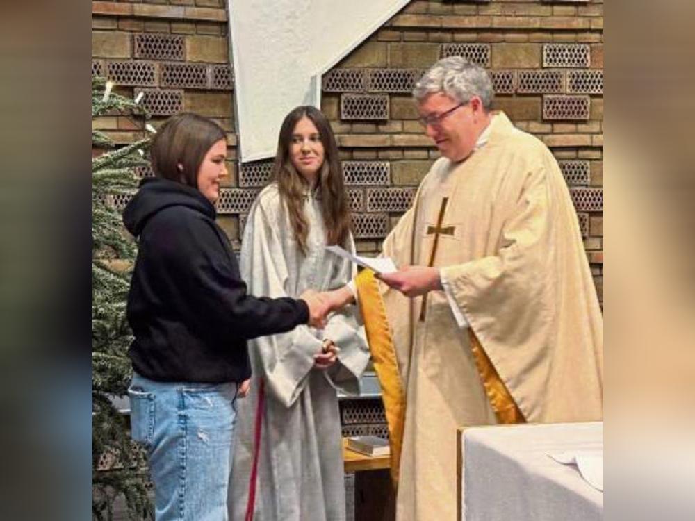 Schüler überreichen Pater Radina ein Abschiedsgedicht.
