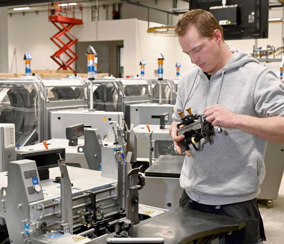 Ersatzteilaustausch an der Transportkette: Betriebstechniker Michael Schott an der Versandmaschine, mit der Beilagen in die Zeitung gelegt werden. Fotos: Rother