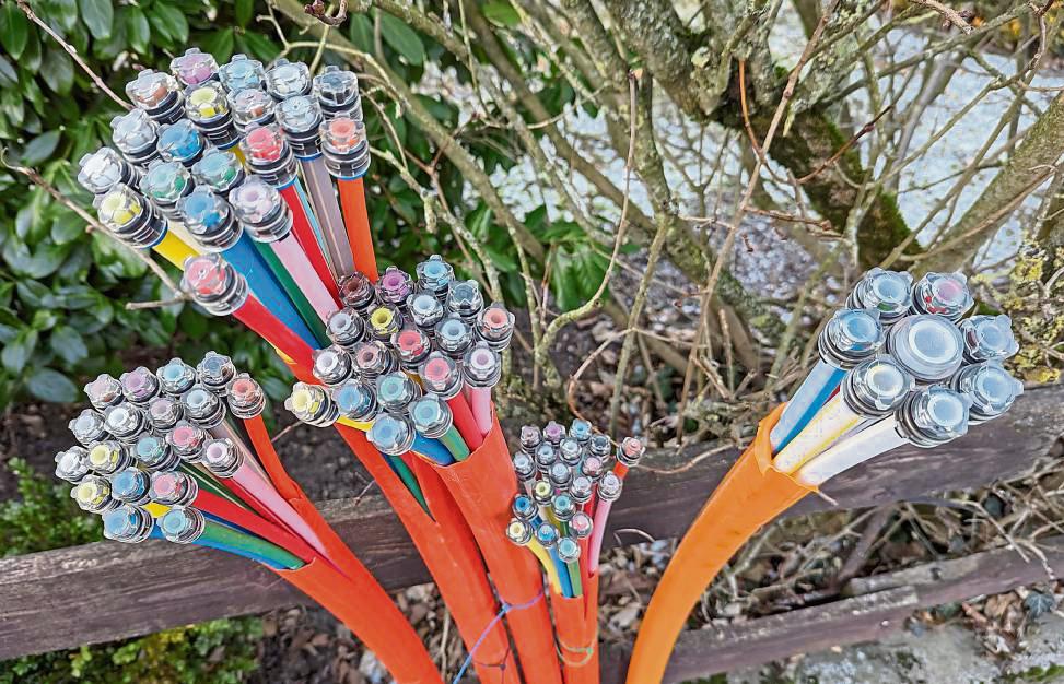 Ein buntes Bouquet, das derzeit aber eher für Frust statt Freude sorgt: Auch wenn die Kabel wie hier in der Antoniusstraße bereits aus der Straße ragen – mit Highspeed kann in Uelde bisher noch niemand surfen. Foto: Raestrup