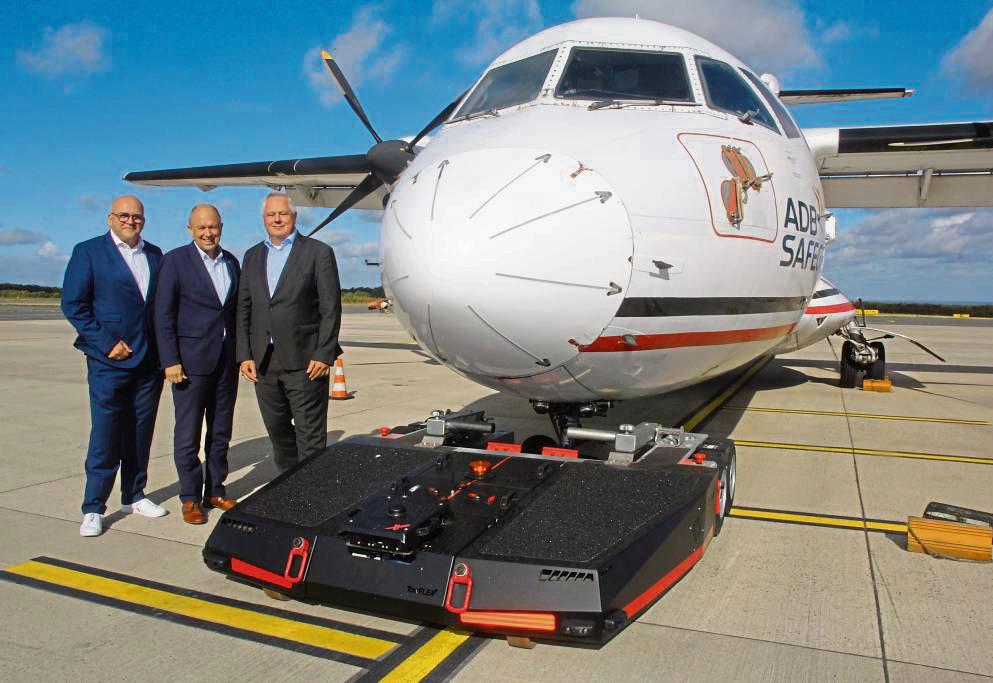 Noch hat das Schleppgerät für Flugzeuge nicht mal einen Namen – aber das Startsignal für eine sechsmonatige Testphase gaben (v.l.) Flughafen-Chef Roland Hüser, Landrat und Aufsichtsrat-Vorsitzender Christoph Rüther und Konsortialführer Stefan Schröder. Foto: Schwade