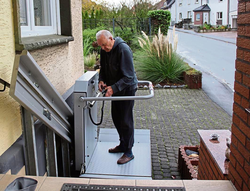 Wienand Fromme zeigt, wie der Treppenlift für Rollstühle an seinem Haus funktioniert. Er würde den Lift gerne an eine Familie mit Bedarf verschenken. Foto: Pia Mintert