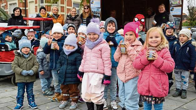 Stolz präsentieren die Kita-Kinder ihr selbstgemachtes Apfelmus. Foto: Kossack