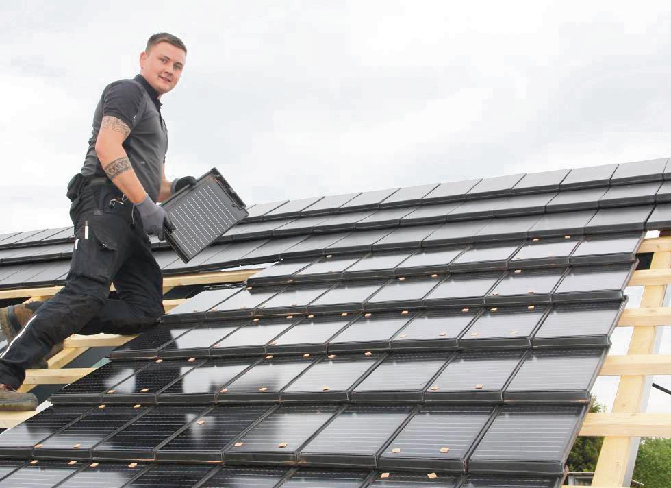 Dachpfanne und Photovoltaik als Zwei-in-eins-Modul: Dachdecker Tim Hils deckte die Ausstellung bei Luttmann mit dem neuen Solarziegel ein. Fotos: Schwade