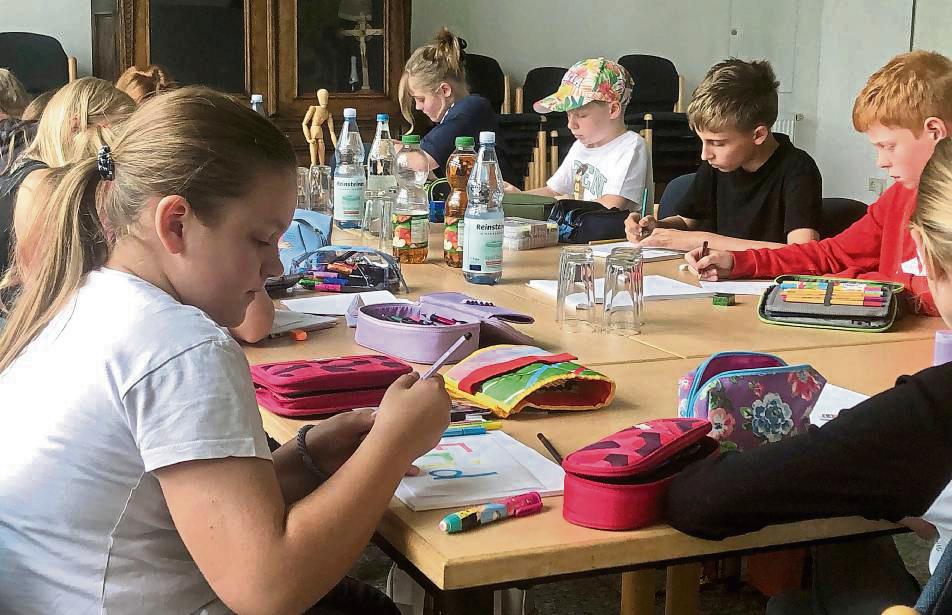 Namensschilder mit Persönlichkeit: Die Kinder arbeiten konzentriert. Foto: Bußmann