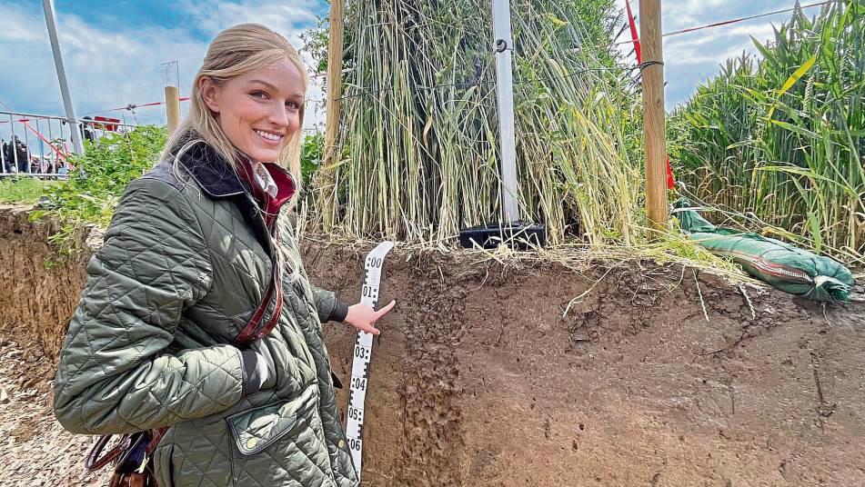 Bodenkunde: Am Stand der Fachhochschule Südwestfalen wurde die Erde bis zum Grundwasser ausgehoben, um Bodenstruktur und Verwurzelungen anschaulich zu machen. Die kleinen Löcher, auf die Marie Hoffmann zeigt, sind Gänge von Regenwürmern. Fotos: Vielberg