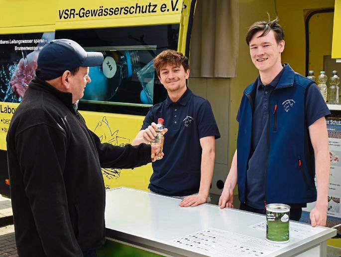 Bundesfreiwilliger Elias Güttner (M.) und Milan Toups (r.) nehmen eine Brunnenwasserprobe entgegen.