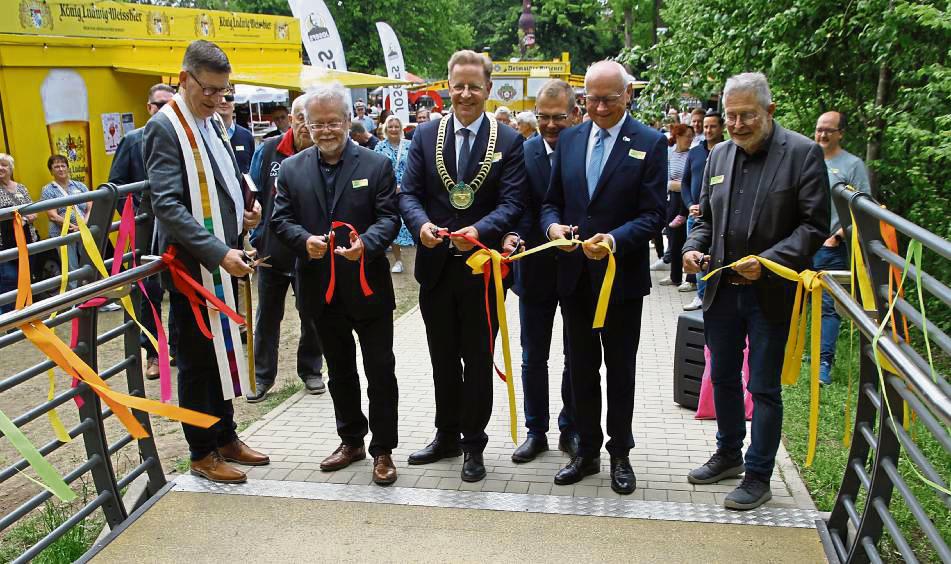 Band durchschnitten, Brücke eröffnet: (v.l.) Pastor Martin Beisler, Pfarrer Olaf Sommer, Bürgermeister Ulrich Berger, Martin Westermeier (Stadt Salzkotten), stellv. Landrat Hans-Bernd Janzen und Jörg List (Städtebauförderung Bezirksregierung Detmold). Foto: Büttner