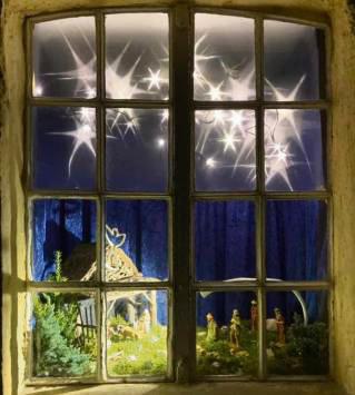 In einem der Mühlenfenster ist eine Krippe zu sehen.