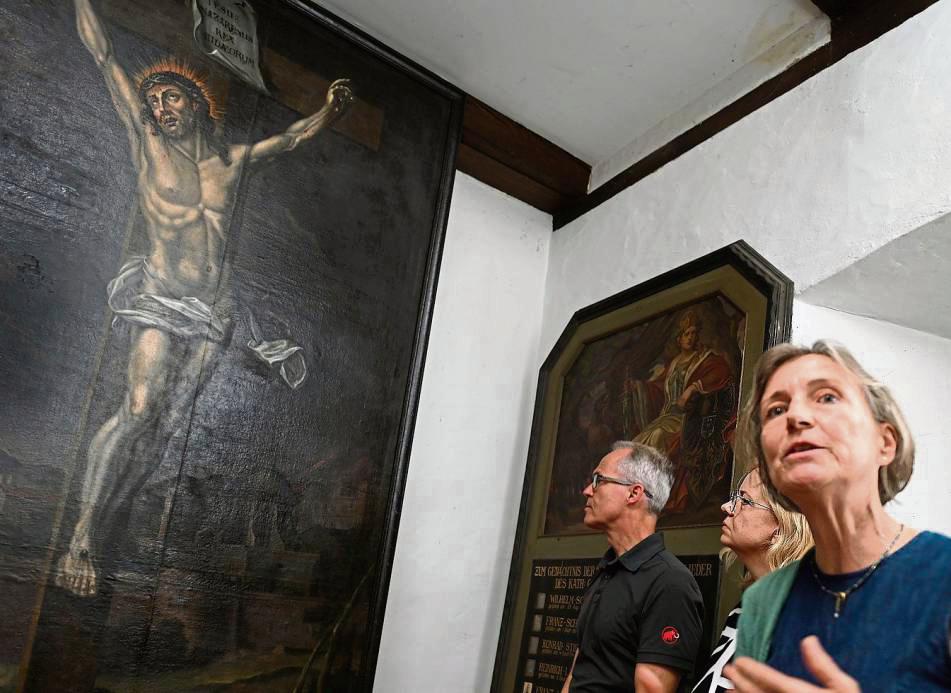 Monika Voss-Raker erläutert den Besuchern die aufwendige Restaurierung des Altarbildes „Christus am Kreuz“. Fotos: Tuschen