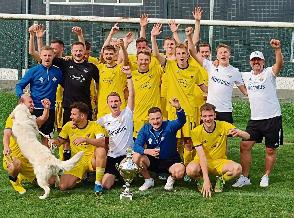 Jetzt wird gefeiert. Riesengroß war der Jubel im Lager des TuS Ehringhausen nach dem Gewinn des Amtspokals. Und selbst der Vierbeiner freute sich nach der Siegerehrung zusammen mit dem neuen Titelträger. Fotos: Brand