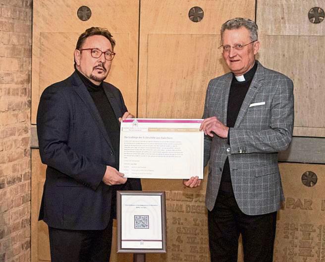 Reinhold Harnisch (l.) und Dompropst Joachim Göbel stellen den QR-Code vor, über den Interessierte mehr Informationen auch über Missbrauch im Erzbistum erhalten können.