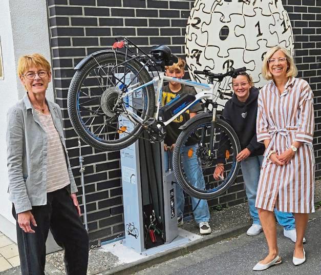 Freuen sich über die neue Fahrrad-Servicestation: Janine Biernatowski vom Förderverein (r.), Schulleiterin Gaby Lütkehellweg (l.) und zwei Schüler der Klassenstufe 7.