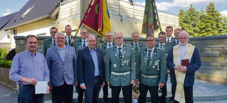 Freuen sich über die Sanierung von Ehrenmal und Fahnen (vorne v.l.): Ortsvorsteher Robert Oesterhoff, Alfons Levenig (Leader Verbund), Bürgermeister Peter Weiken, Ehrenvorsitzender Karl-Josef Beiteke, Vorsitzender Markus Schulze, Pastor Stefan Gosmann sowie der Vorstand der St. Nikolaus Schützenbruderschaft (hintere Reihe). Foto: Thomas