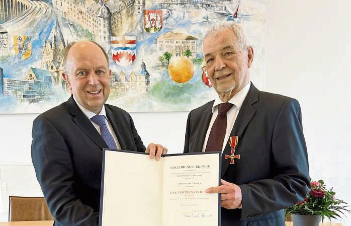 Landrat Christoph Rüther (l.) überreicht Heinrich Emrich das Verdienstkreuz am Bande.