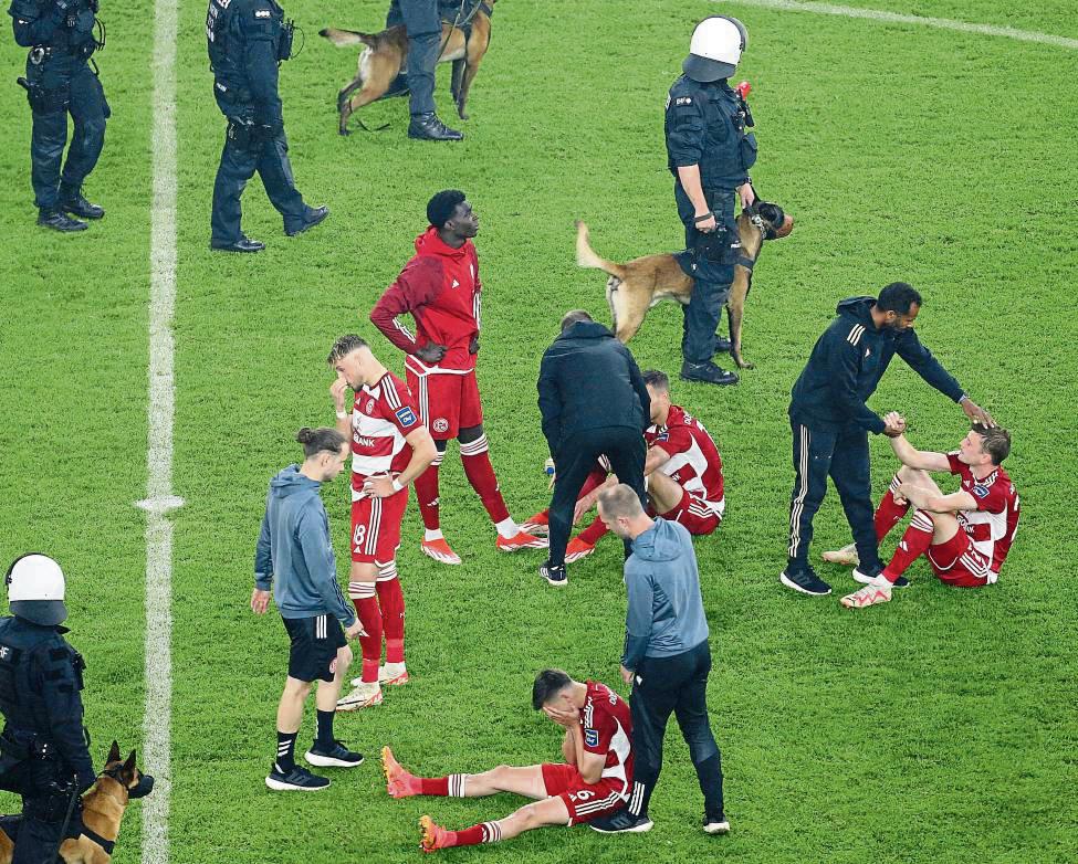 Relegations-Drama: Nach dem K.o. im Elfmeterschießen gegen Bochum müssen die Spieler von Fortuna Düsseldorf getröstet werden. Mittendrin ist auch Frank Hörstmann aus Belecke (ganz vorne, Mitte, mit langer schwarzer Hose), Physio beim Zweitliga-Club. Foto: DPA
