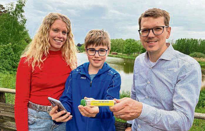 Luca Spratte zeigt Gartenschaupark-Geschäftsführer Johannes Wiethoff und Mitarbeiterin Laura Hunke eines der Kunststoffröhrchen, die es zu finden gilt. Insgesamt zehn der sogenannten Caches hat der Zwölfjährige im Park und in der näheren Umgebung versteckt.