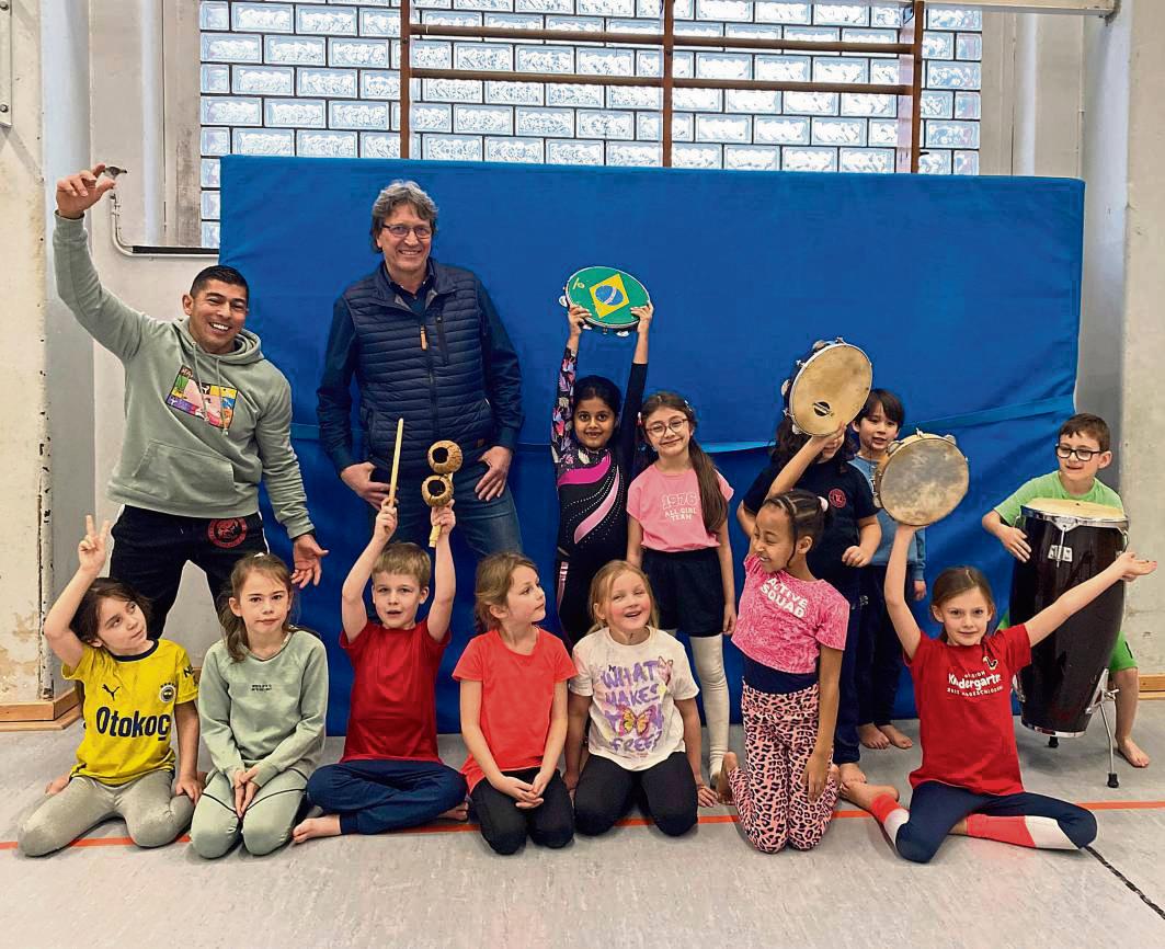 Capoeira-Profi William Gomes Soares von Viva Brasil (hinten, l.) und Schulleiter Andreas Brauckmann (hinten, 2.v.l.) freuen sich mit den Friedrichschülern über das neue Angebot.