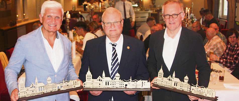 Ein Lichterbogen mit Silhouette der Stadt und der Köhler-Gebäude als Jubiläumsgeschenk: Das 75-Jährige feierten mit den Beschäftigten (v.l.) Geschäftsführer Dr. Hans Jürgen Kracht, Vorgänger Norbert Börnemeier und Jürgen von Wendorff (Hannover Finanz). Foto: Wissing