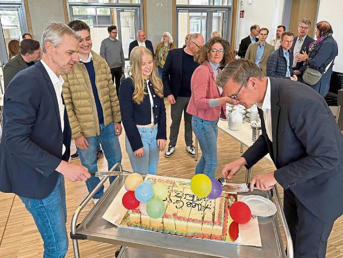 Eine Torte zum Einzug: Schulleiter Matthias Stolper (l.) und Bürgermeister Andreas Sunder kümmerten sich nach dem Durchtrennen des roten Bandes auch um die Bewirtung der Gäste.